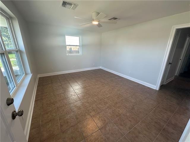 spare room with a wealth of natural light and ceiling fan