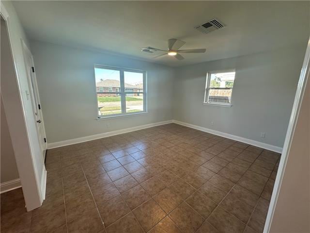 tiled spare room with ceiling fan and a healthy amount of sunlight