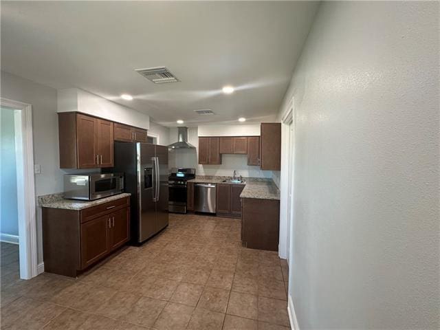 kitchen featuring dark brown cabinetry, sink, wall chimney exhaust hood, and stainless steel appliances