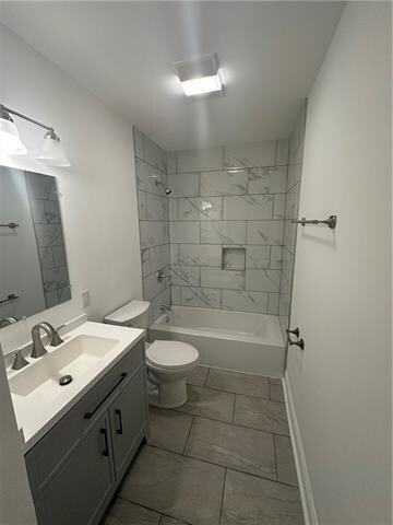 full bathroom featuring toilet, vanity, and tiled shower / bath