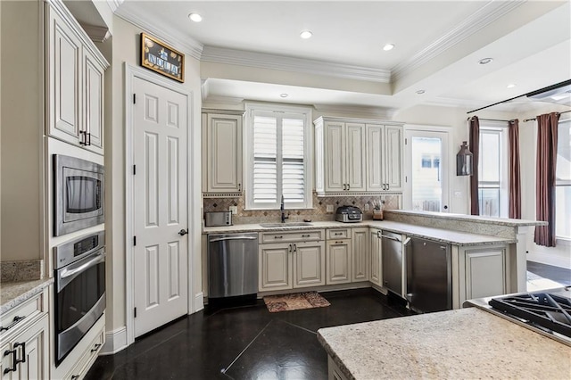 kitchen featuring appliances with stainless steel finishes, decorative backsplash, sink, ornamental molding, and a tray ceiling