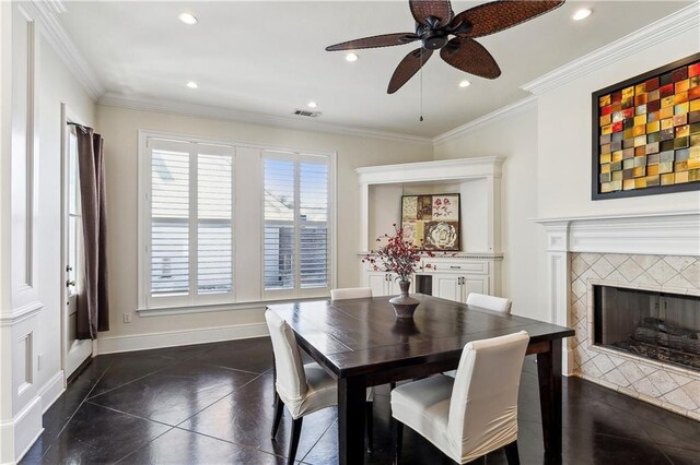 dining room with a fireplace, ceiling fan, and ornamental molding