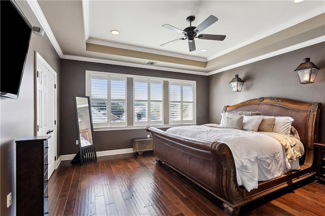 bedroom with ceiling fan, crown molding, dark hardwood / wood-style flooring, and a tray ceiling