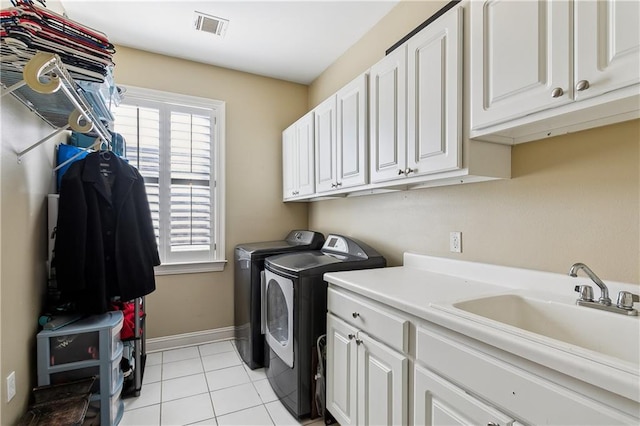 clothes washing area with sink, cabinets, a healthy amount of sunlight, and separate washer and dryer