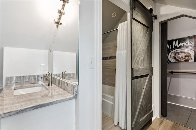 bathroom with vanity, hardwood / wood-style flooring, bathtub / shower combination, and lofted ceiling