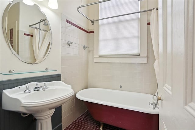 bathroom featuring a tub to relax in, tile patterned flooring, and tile walls