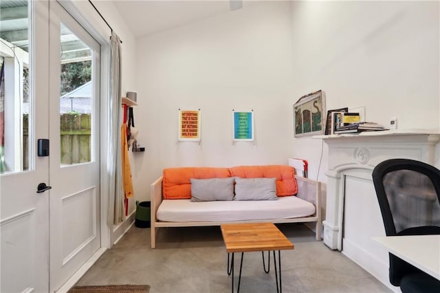 sitting room featuring lofted ceiling and light carpet