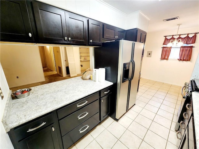 kitchen with stove, stainless steel refrigerator with ice dispenser, ornamental molding, light tile patterned floors, and decorative light fixtures