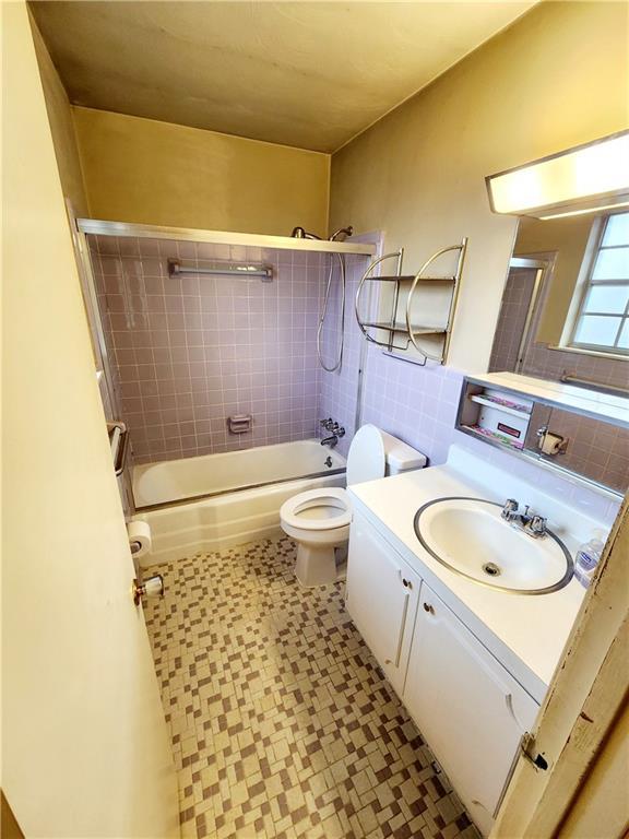 utility room with gas water heater, washer and clothes dryer, and sink