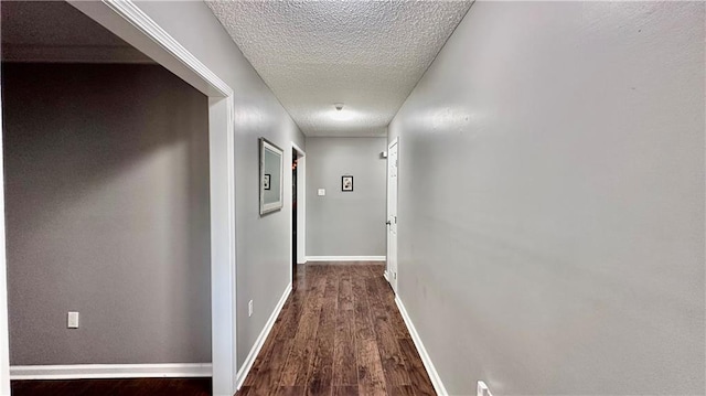 corridor with hardwood / wood-style floors and a textured ceiling