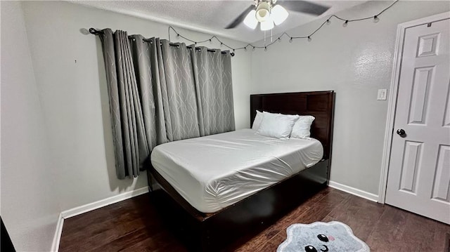 bedroom with dark wood-type flooring, ceiling fan, and a textured ceiling