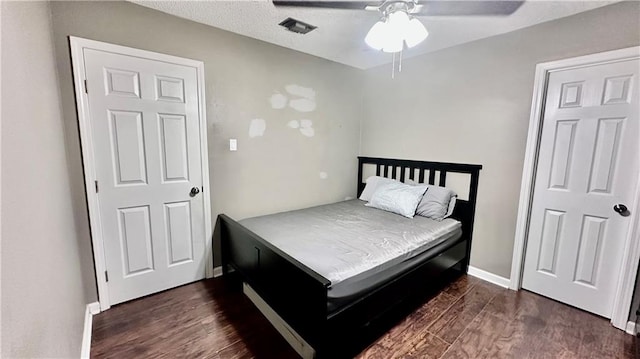 bedroom featuring a textured ceiling, dark hardwood / wood-style flooring, and ceiling fan