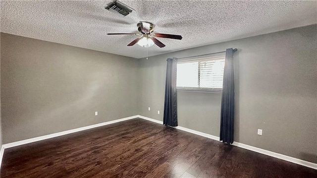 empty room featuring dark hardwood / wood-style flooring, a textured ceiling, and ceiling fan