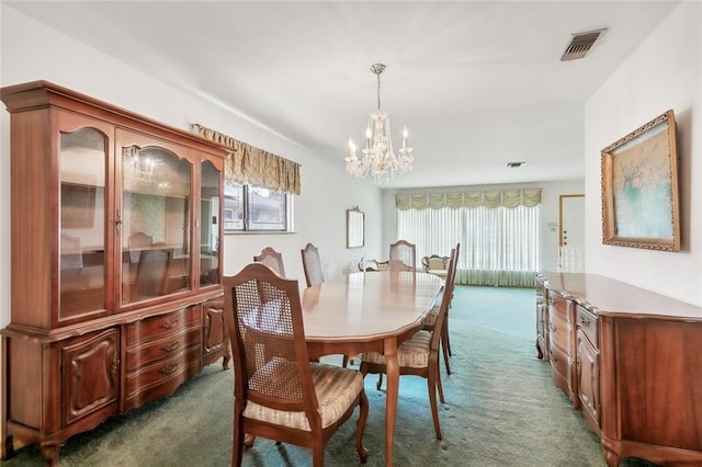 dining area featuring a notable chandelier and dark colored carpet