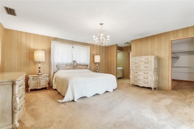 carpeted bedroom featuring a walk in closet, wooden walls, a closet, and an inviting chandelier