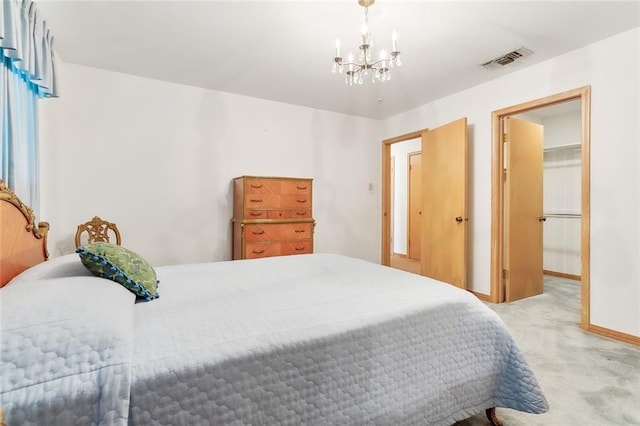 bedroom featuring carpet flooring, a walk in closet, a closet, and a notable chandelier