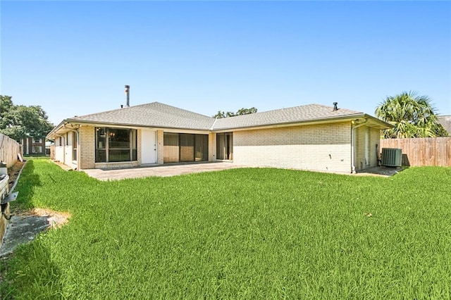 rear view of property with cooling unit, a patio area, and a yard