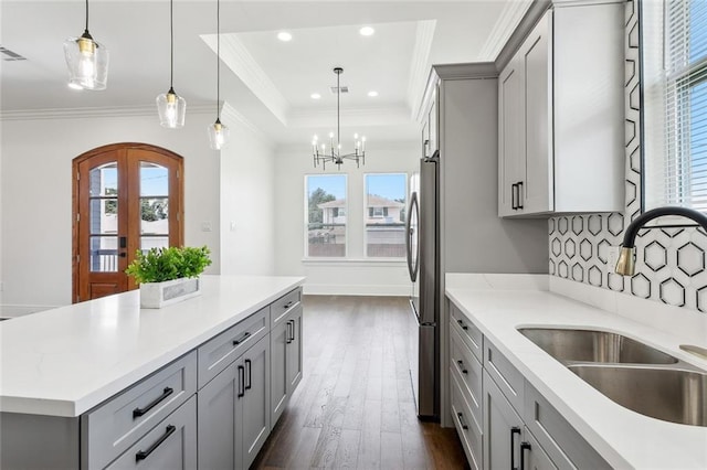 kitchen featuring gray cabinets, dark wood-type flooring, hanging light fixtures, and sink