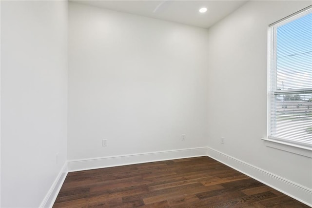 empty room featuring a healthy amount of sunlight and dark hardwood / wood-style flooring