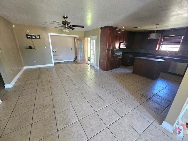 kitchen featuring ceiling fan, a textured ceiling, light tile patterned floors, black range with electric stovetop, and pendant lighting