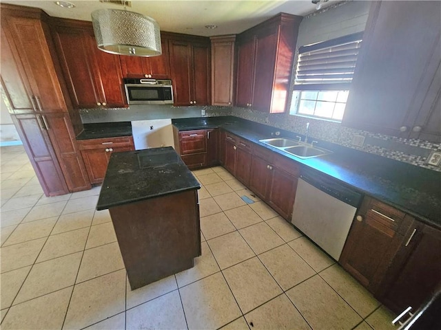 kitchen with dishwasher, sink, tasteful backsplash, light tile patterned flooring, and a kitchen island