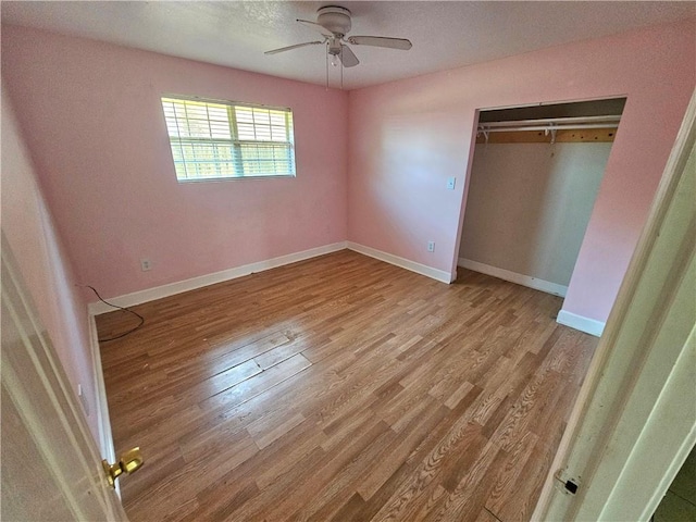 unfurnished bedroom with light wood-type flooring, ceiling fan, and a closet