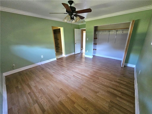 unfurnished bedroom with ceiling fan, a closet, crown molding, and wood-type flooring