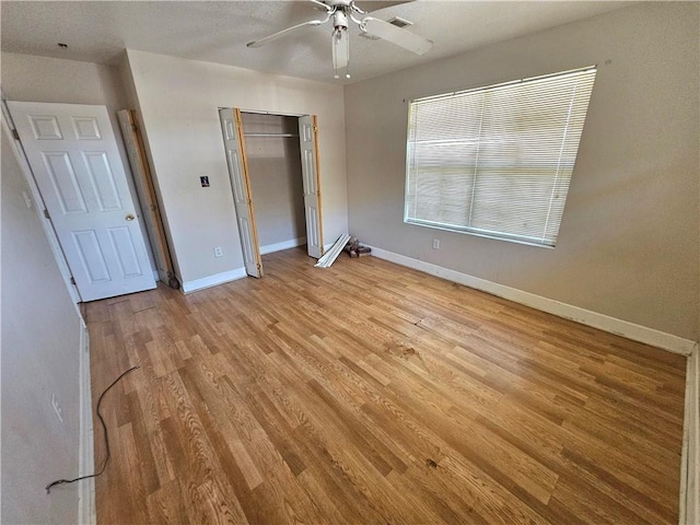 unfurnished bedroom featuring a closet, light hardwood / wood-style floors, and ceiling fan