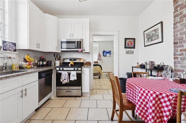 kitchen with appliances with stainless steel finishes, sink, and white cabinetry