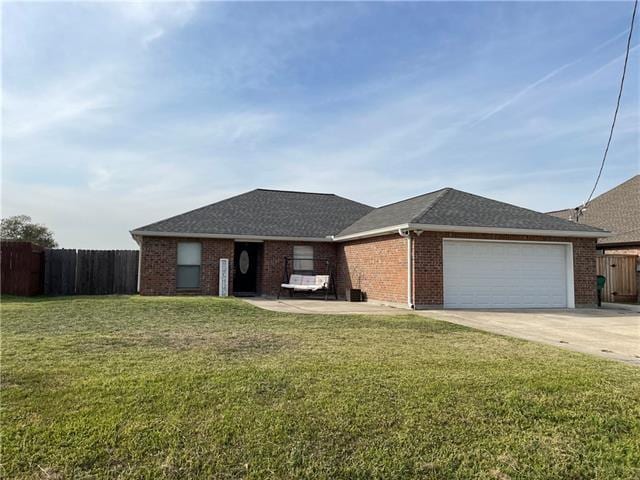 single story home with a garage and a front lawn