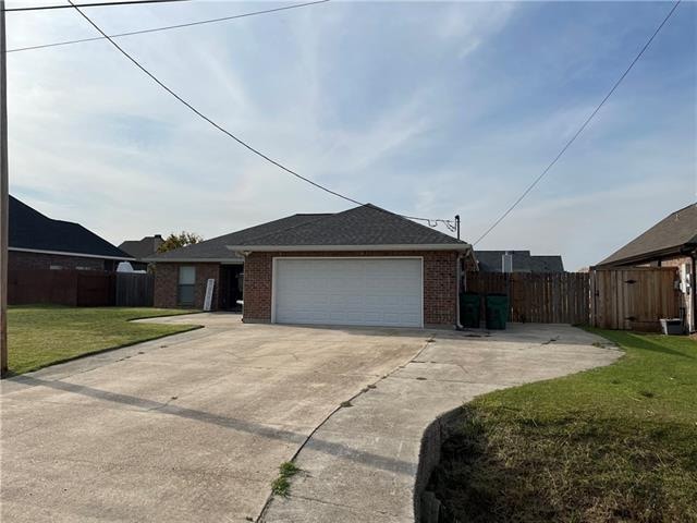 view of side of property featuring a garage and a lawn