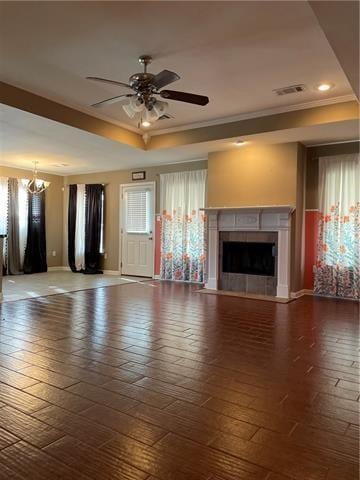 unfurnished living room featuring wood-type flooring, ceiling fan with notable chandelier, ornamental molding, and a fireplace