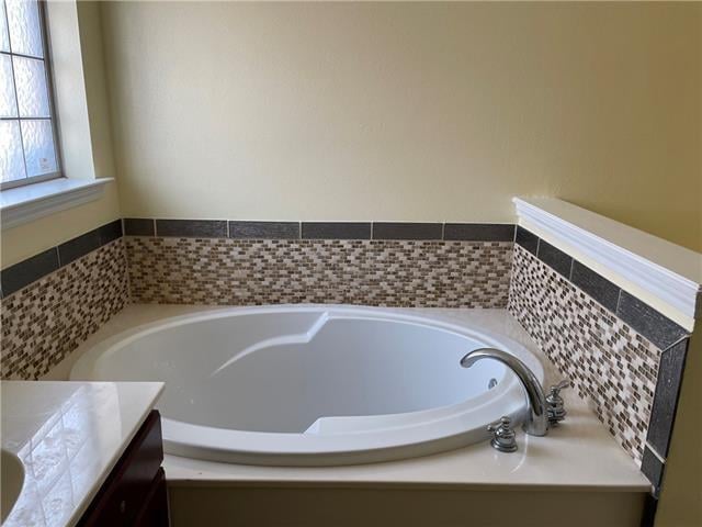 bathroom with vanity and a relaxing tiled tub