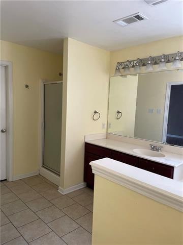 bathroom featuring vanity, tile patterned floors, and a shower with shower door