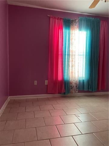 empty room featuring tile patterned floors and ceiling fan