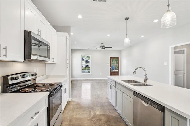 kitchen with sink, decorative light fixtures, white cabinets, and appliances with stainless steel finishes