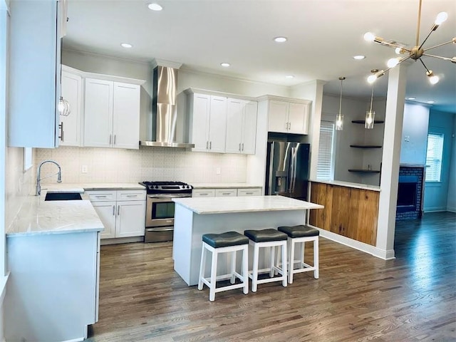 kitchen with wall chimney exhaust hood, stainless steel appliances, dark wood-type flooring, white cabinets, and a center island