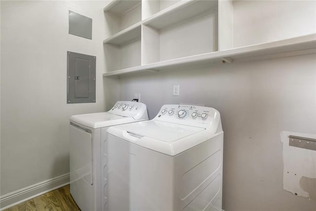 laundry room featuring washer and clothes dryer, hardwood / wood-style floors, and electric panel