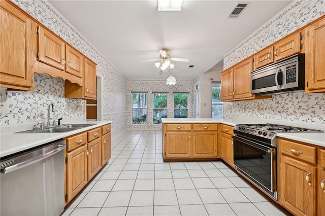 kitchen with light tile patterned flooring, appliances with stainless steel finishes, sink, kitchen peninsula, and ceiling fan