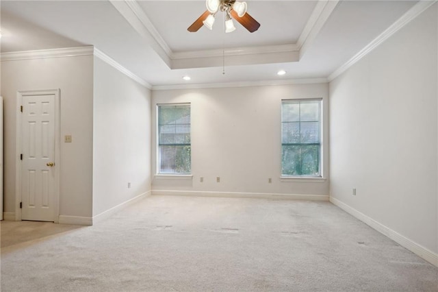 carpeted empty room featuring ornamental molding, ceiling fan, and a tray ceiling