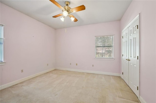 carpeted spare room with ceiling fan