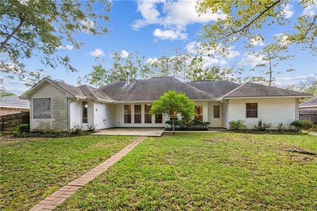 rear view of house with a patio and a lawn