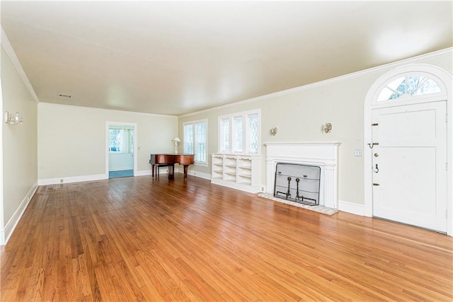 unfurnished living room with crown molding, a healthy amount of sunlight, and hardwood / wood-style flooring