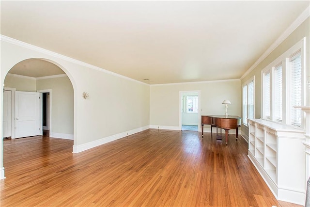 spare room featuring hardwood / wood-style flooring, a healthy amount of sunlight, and crown molding