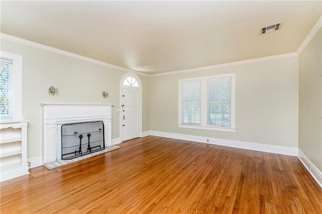 unfurnished living room with hardwood / wood-style floors, plenty of natural light, and ornamental molding