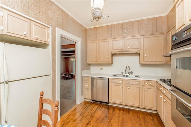 kitchen featuring light brown cabinetry, sink, stainless steel appliances, and hardwood / wood-style flooring