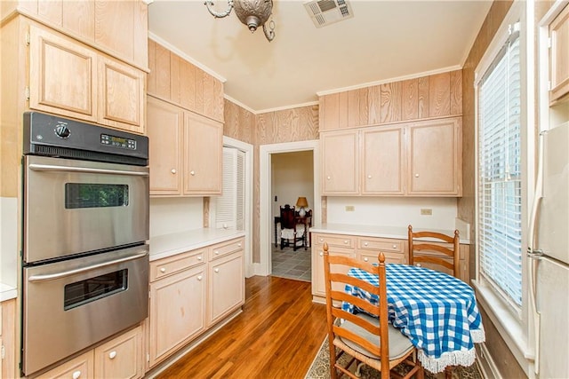 kitchen with plenty of natural light, white fridge, stainless steel double oven, and dark wood-type flooring