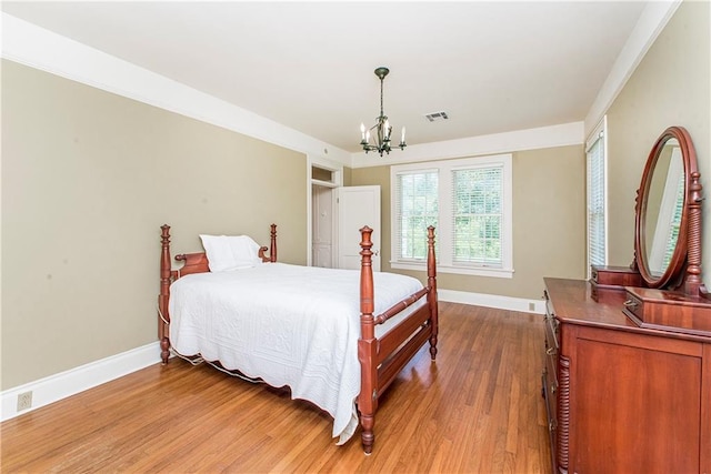 bedroom with a chandelier and wood-type flooring