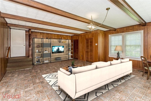 living room featuring beam ceiling and wooden walls