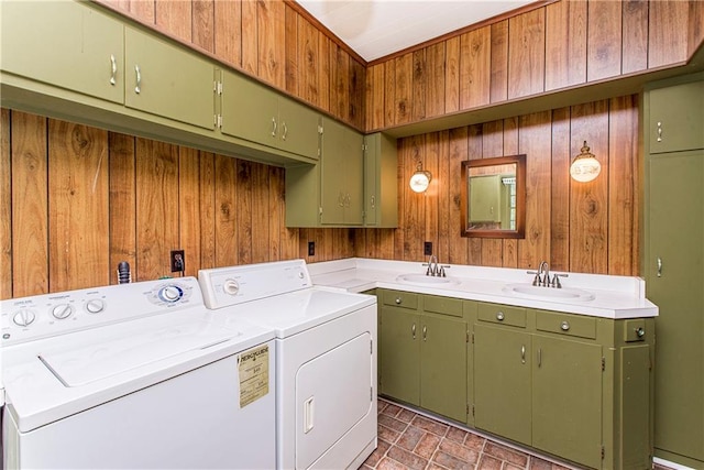 laundry room with wood walls, cabinets, separate washer and dryer, and sink